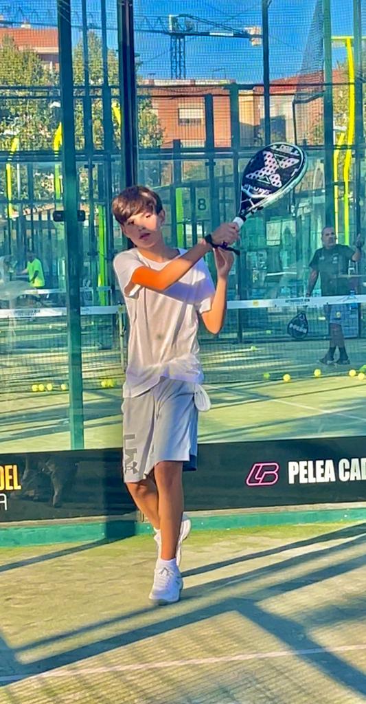 Niño aprendiendo pádel con pala junior - Academia Internacional de Pádel Barcelona programa infantil