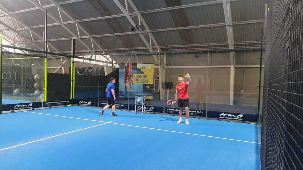 Modern indoor padel facility with covered court showing professional training session at Barcelona academy Spain